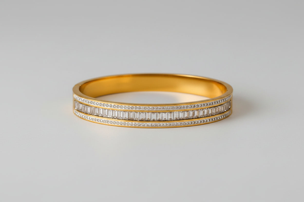 This gold-plated bangle features a luxurious triple-row design