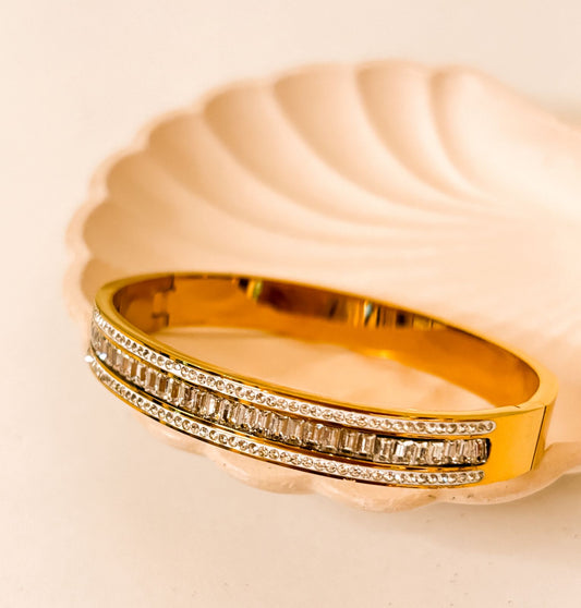 This gold-plated bangle features a luxurious triple-row design